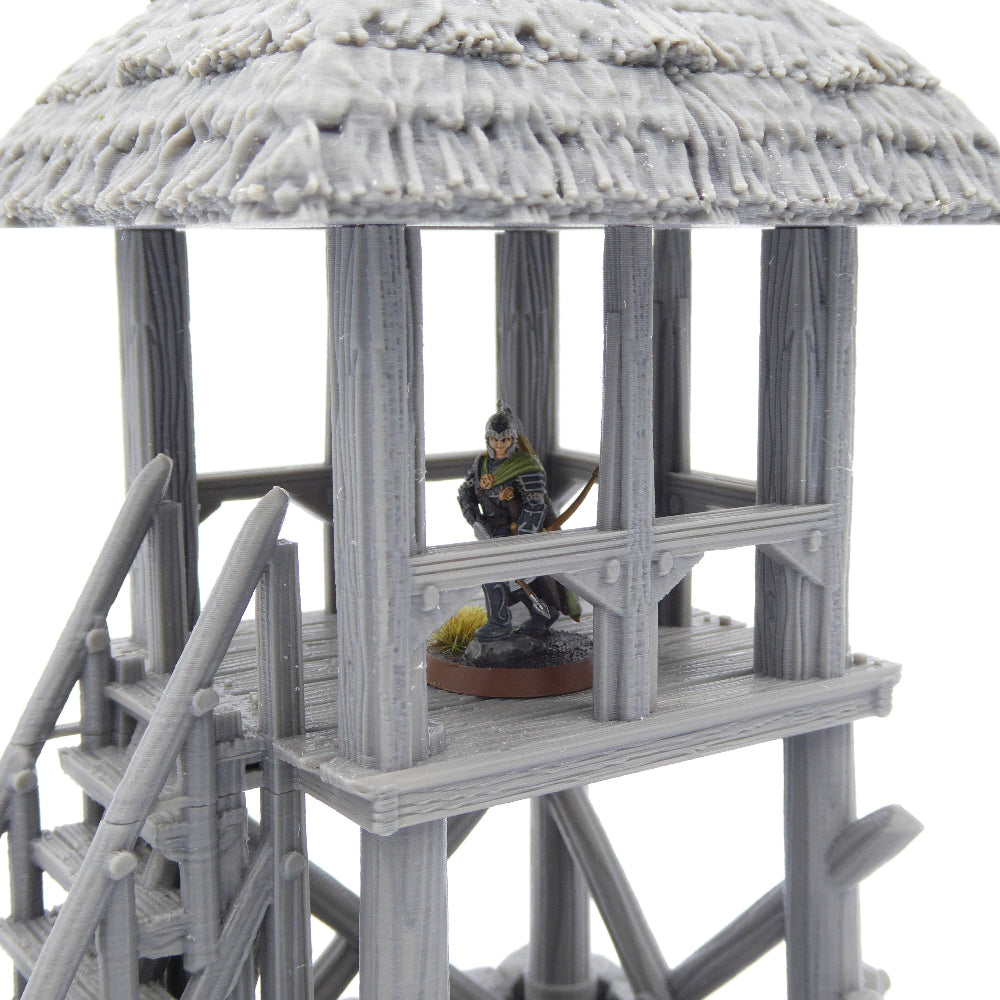 Model of a wooden watchtower with a figure on top, set against a white background