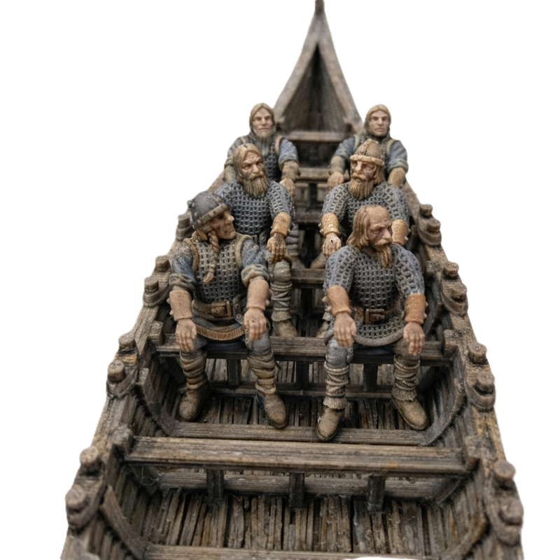 Model of a longship with five figures on a white background