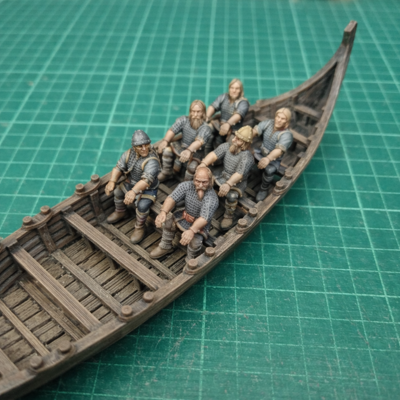 Model of a longboat with figures on a green cutting mat