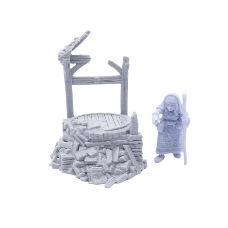 Grey miniature model of a well and a figure on a white background