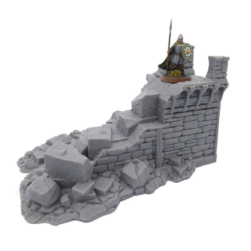 Model of a stone wall with a figure on top against a white background