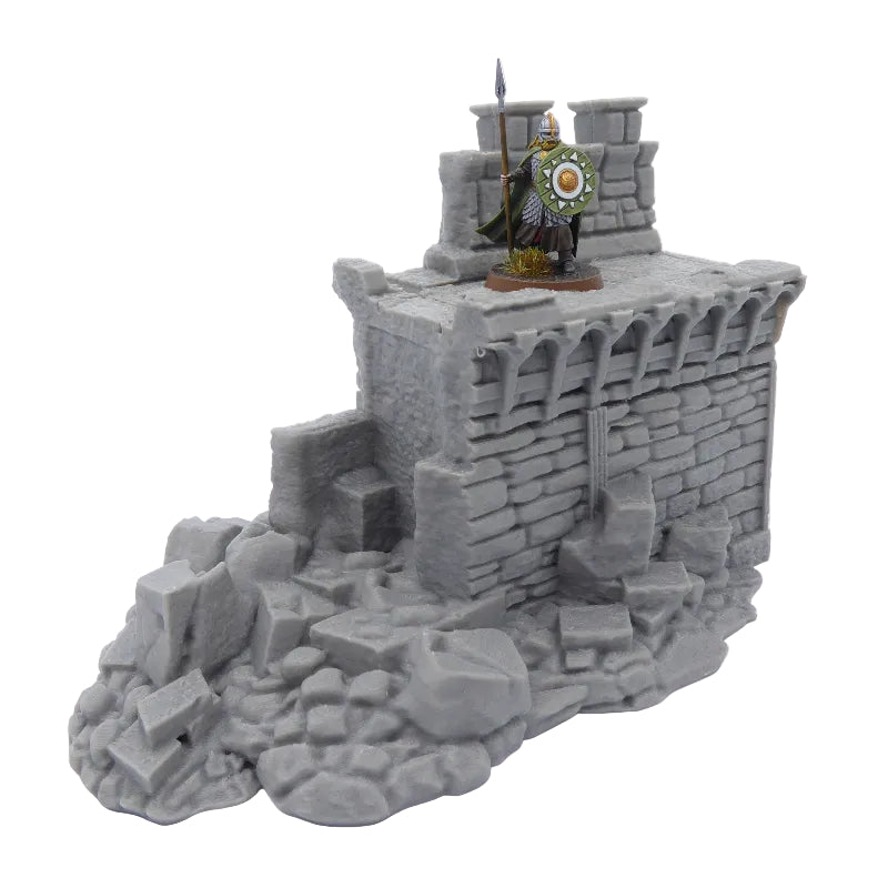 Model of a castle wall with a figure on top against a white background