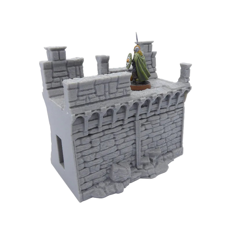 Model of a stone castle tower with a figure on top against a white background